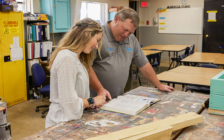 Kara and man looking at book